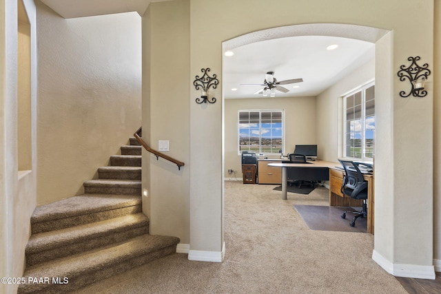 carpeted office space with recessed lighting, ceiling fan, baseboards, and arched walkways
