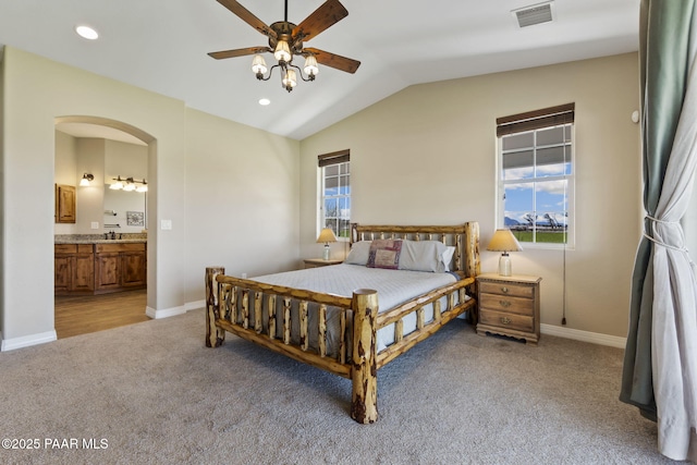 bedroom with vaulted ceiling, visible vents, light carpet, and multiple windows