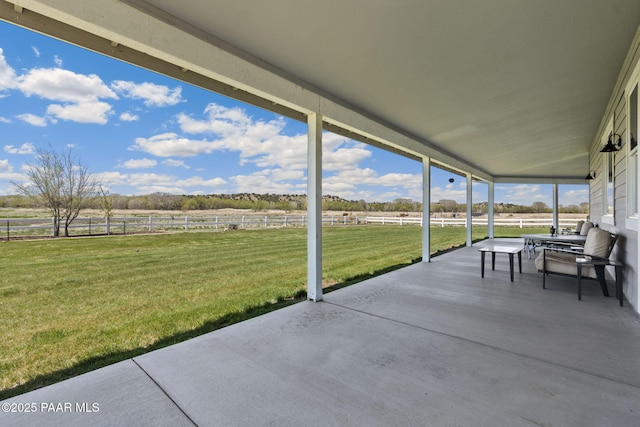 view of patio featuring a rural view and fence