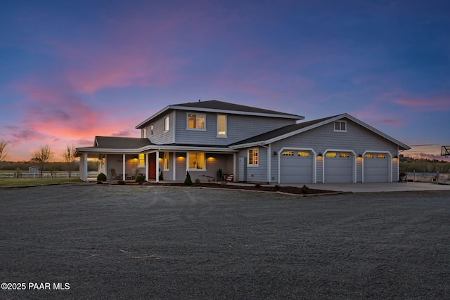 traditional-style house with a garage, covered porch, and driveway