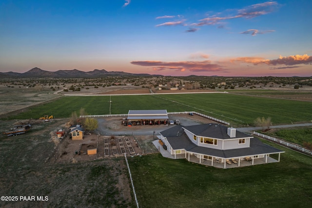 aerial view at dusk featuring a rural view and a mountain view
