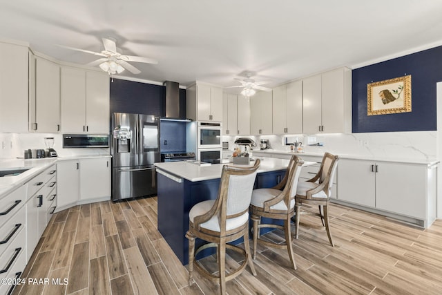 kitchen featuring white cabinets, stainless steel appliances, and light hardwood / wood-style flooring