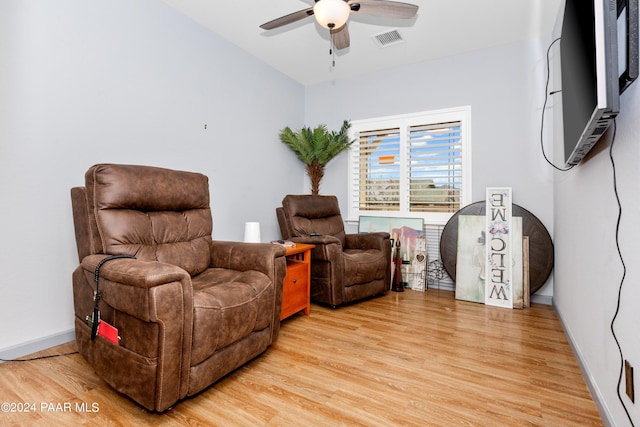 sitting room with baseboards, light wood-style floors, visible vents, and ceiling fan