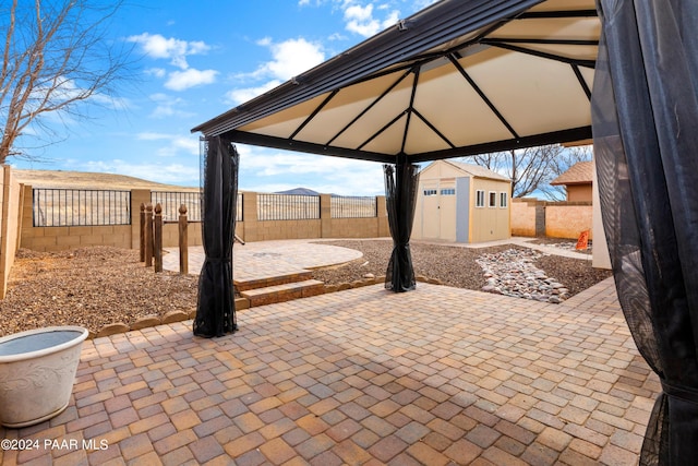 view of patio / terrace featuring a gazebo, an outbuilding, and a fenced backyard