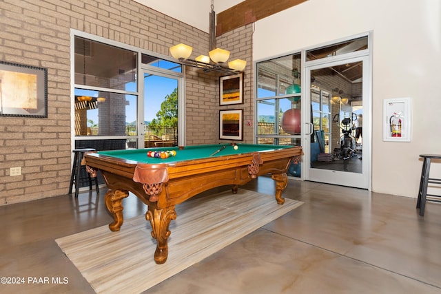 game room with concrete floors, brick wall, and billiards