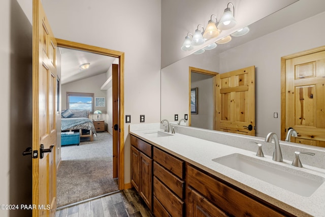 bathroom with hardwood / wood-style flooring, vanity, lofted ceiling, and a notable chandelier