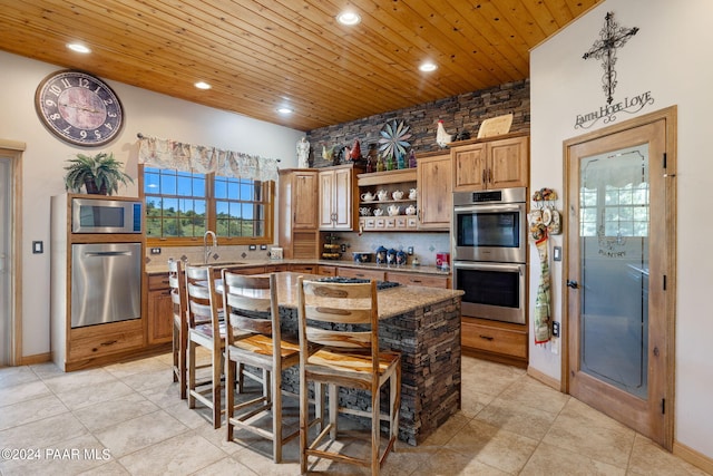 kitchen with sink, stainless steel appliances, backsplash, a kitchen island, and wood ceiling