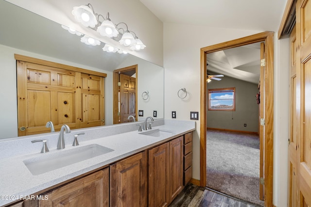 bathroom featuring ceiling fan, vanity, vaulted ceiling, and hardwood / wood-style flooring