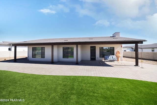 rear view of house with a patio and a lawn