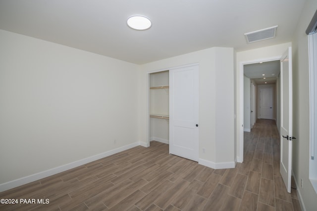 unfurnished bedroom featuring wood-type flooring and a closet