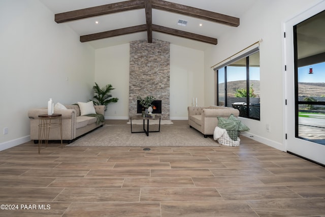 living room with vaulted ceiling with beams, a mountain view, and a fireplace