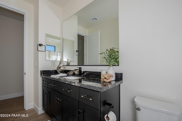 bathroom with vanity, toilet, and wood-type flooring