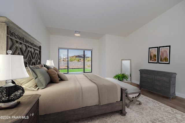 bedroom with wood-type flooring and vaulted ceiling