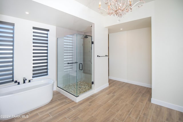 bathroom with a chandelier and shower with separate bathtub