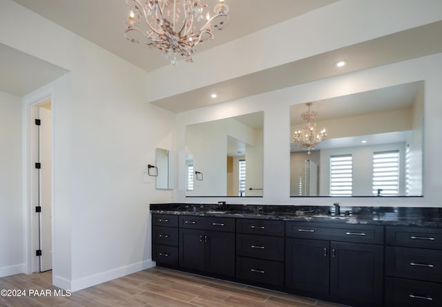 bathroom with hardwood / wood-style floors, vanity, and a notable chandelier