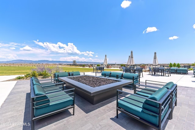 view of patio / terrace with a mountain view and a fire pit