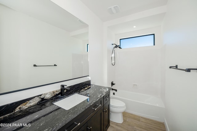 full bathroom with hardwood / wood-style floors, vanity, toilet, and shower / washtub combination