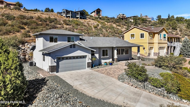 view of front of house with a garage and central AC unit