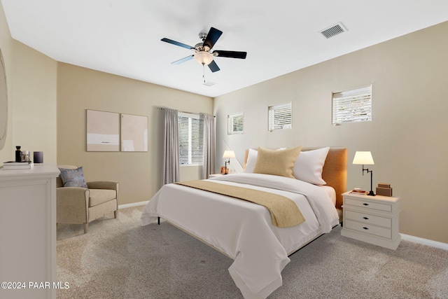 carpeted bedroom with multiple windows and ceiling fan