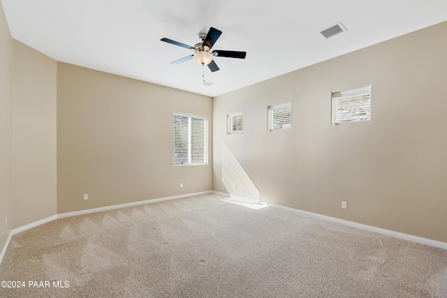 carpeted spare room with ceiling fan