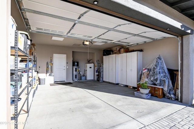 garage with heat pump water heater and a garage door opener