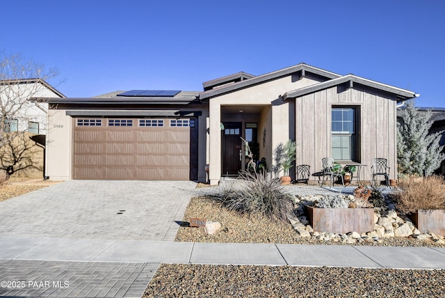 view of front facade with a garage and solar panels