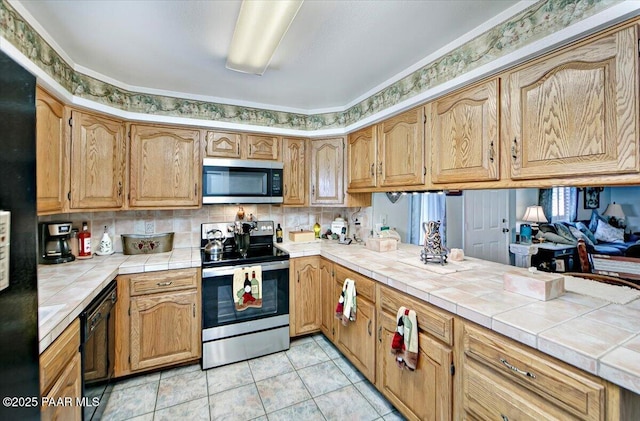 435 Jasmine Ln, Prescott, AZ 86301 - kitchen with decorative backsplash, black appliances, light tile patterned flooring, tile countertops, and a peninsula