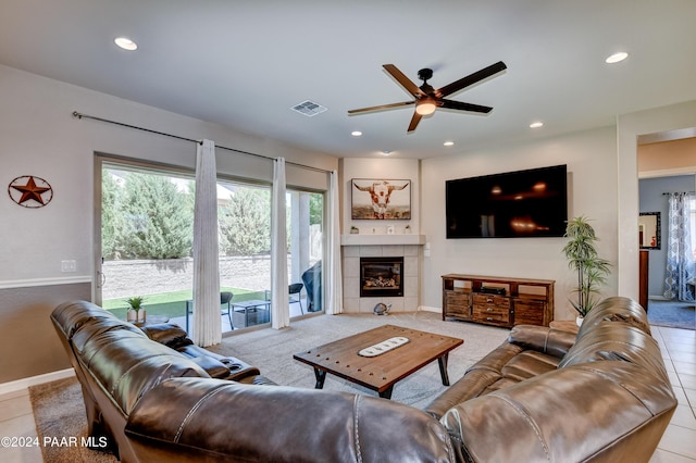 living room with ceiling fan, light tile patterned flooring, and a tile fireplace