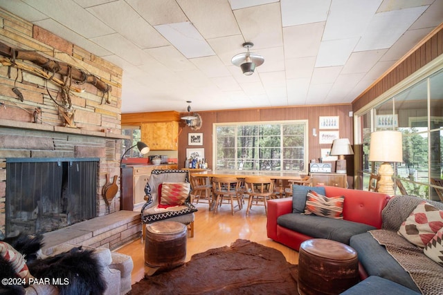 living room with wood walls, a fireplace, and wood finished floors