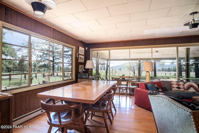 581 Cooper Ranch Rd, Williams, AZ 86046 - dining area with wood walls, baseboard heating, and wood finished floors