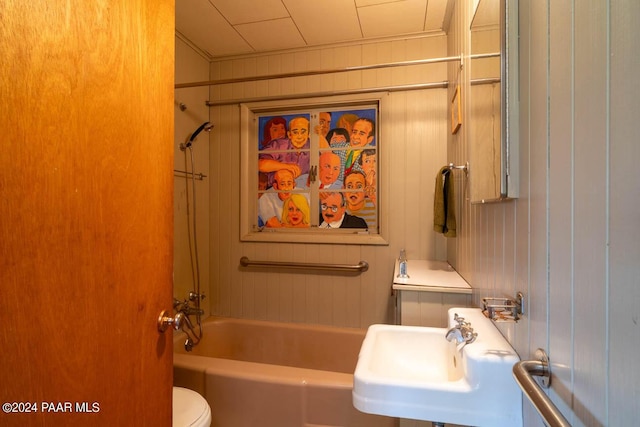 581 Cooper Ranch Rd, Williams, AZ 86046 - bathroom featuring shower / bathtub combination, wood walls, a sink, and toilet
