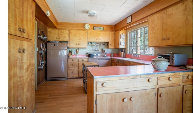 581 Cooper Ranch Rd, Williams, AZ 86046 - kitchen featuring a toaster, a peninsula, stove, light wood-type flooring, and freestanding refrigerator