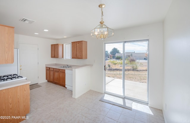 kitchen featuring light countertops, a sink, a chandelier, white appliances, and visible vents