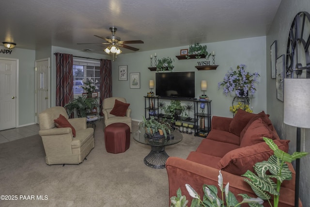 living area featuring a ceiling fan, a textured ceiling, tile patterned flooring, visible vents, and carpet