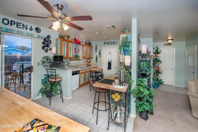 kitchen featuring a ceiling fan, dishwasher, light tile patterned floors, baseboards, and visible vents