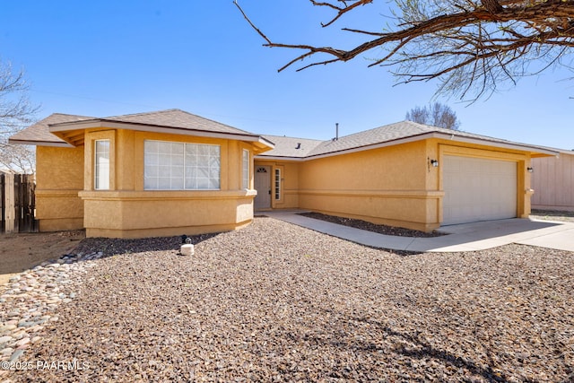 view of front of property featuring fence, roof with shingles, an attached garage, stucco siding, and concrete driveway