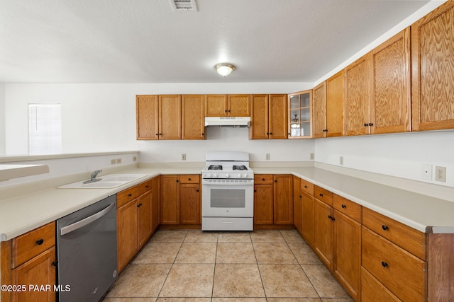 kitchen featuring white range with gas cooktop, a sink, under cabinet range hood, dishwasher, and brown cabinets