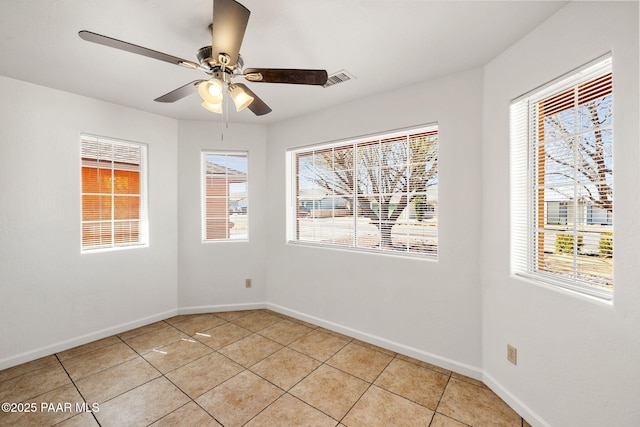 unfurnished room featuring ceiling fan, baseboards, and light tile patterned flooring