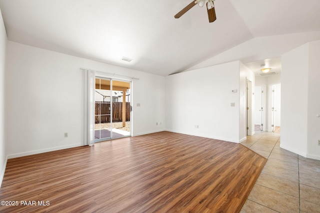 unfurnished room with visible vents, lofted ceiling, wood finished floors, baseboards, and ceiling fan