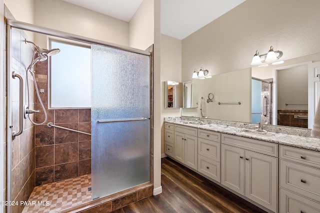 bathroom with hardwood / wood-style floors, vanity, and an enclosed shower