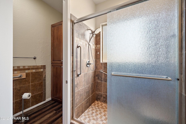 bathroom with an enclosed shower and wood-type flooring