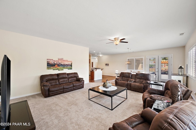 living room with ceiling fan, french doors, and light colored carpet