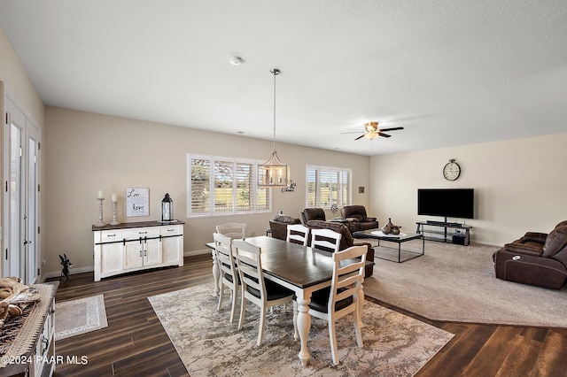 dining space featuring ceiling fan with notable chandelier and dark hardwood / wood-style floors