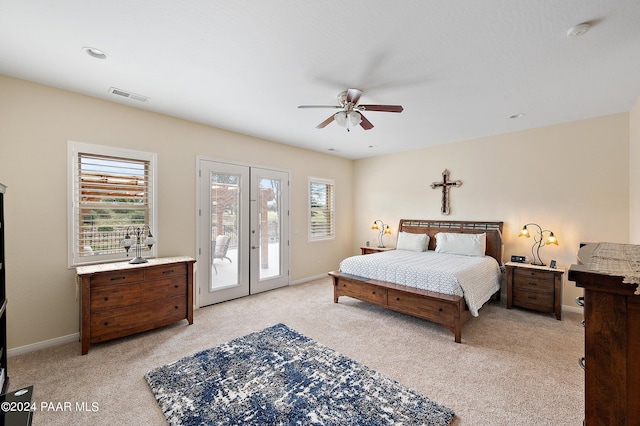 bedroom with ceiling fan, access to exterior, light colored carpet, and multiple windows