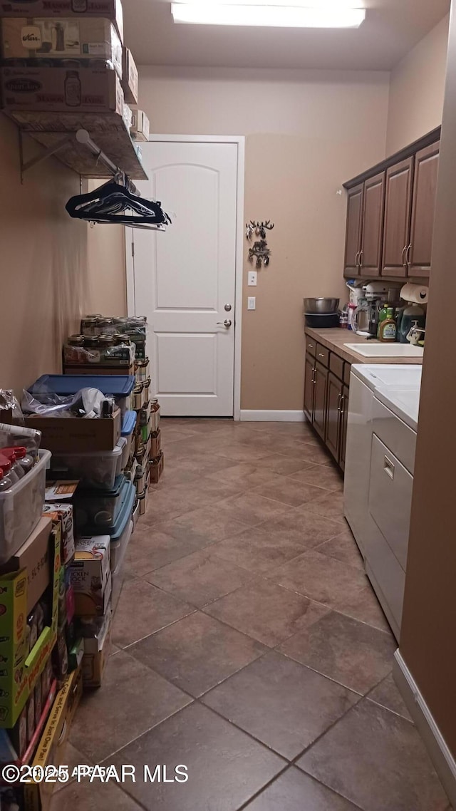 washroom featuring cabinet space, independent washer and dryer, and baseboards
