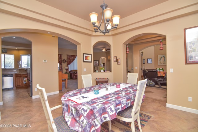 dining space featuring arched walkways, light tile patterned floors, and a chandelier