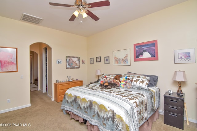 bedroom featuring arched walkways, carpet flooring, baseboards, and ceiling fan