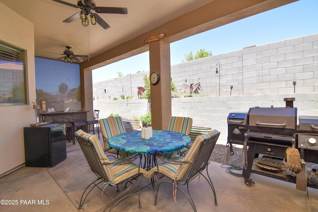 fenced backyard featuring a patio area, outdoor dining area, ceiling fan, and a grill