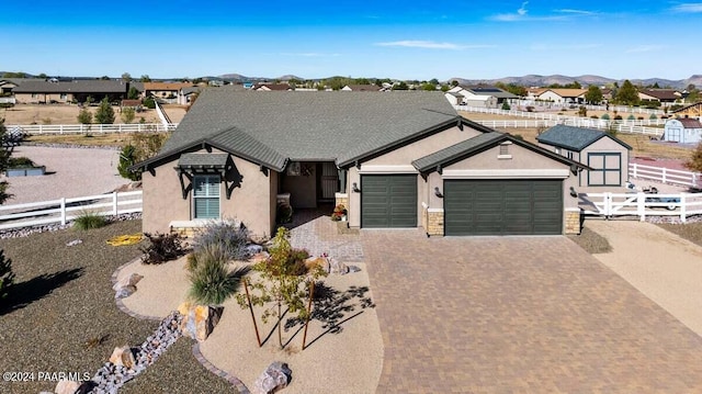 single story home with a mountain view, an outdoor structure, and a garage