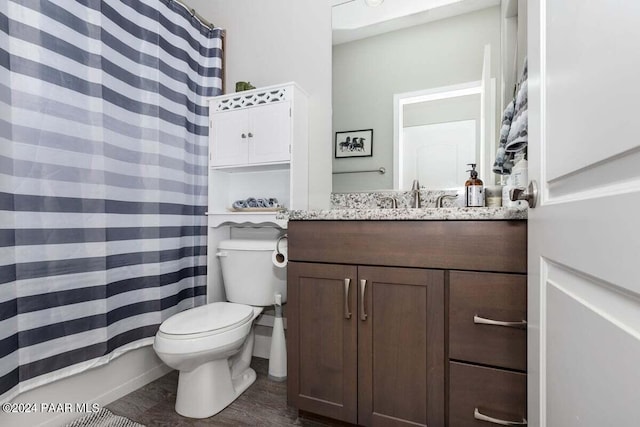 bathroom with hardwood / wood-style flooring, vanity, curtained shower, and toilet